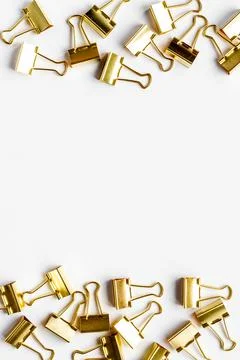Frame of stationery golden paper binder clips top view. Office supplies pattern Stock Photos