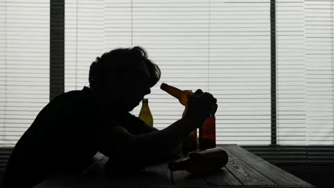 In the frame, a young guy sitting at a table in an institution, a cafe. He sits Stock Footage 252405719