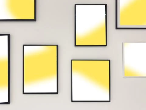 Framed abstract yellow gradient prints arranged on a gray wall. Minimalist Stock Photos