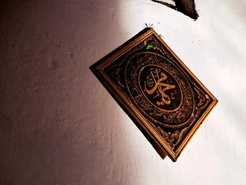 A framed calligraphic artwork featuring the name of the Prophet Muhammad (S.. Stock Photos