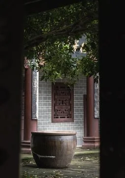 Framed by dark, structural shadows, a hidden courtyard unfolds to reveal a .. Stock Photos