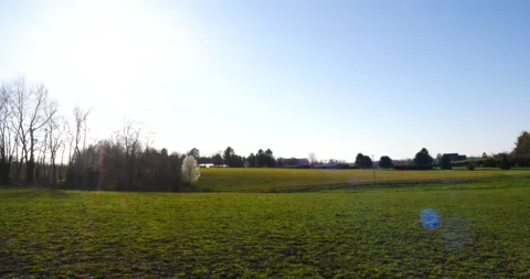 Framed by a fence with trees and clouds in the sky above. Video stock 237692263