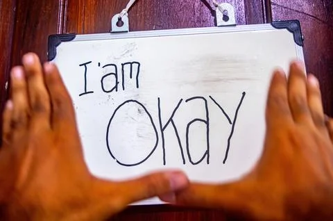 Framed hands highlight a whiteboard with I am Okay message, symbolizing sel.. Stock-Fotos