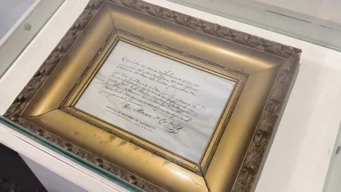 Framed handwritten historical document displayed at Casa Natal de Sarmiento Stock Footage 343990820