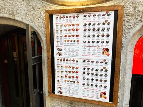 Framed restaurant menu board on a stone wall outside a Barcelona, Spain tap.. Stock Photos