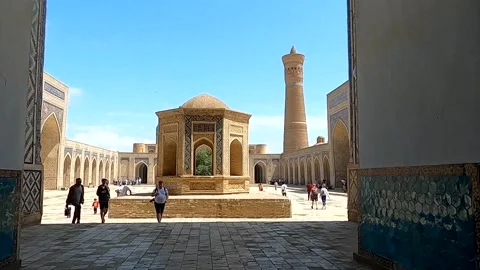 Framed view of Kalyan Mosque courtyard and minaret with tourists Stock Footage 335543230
