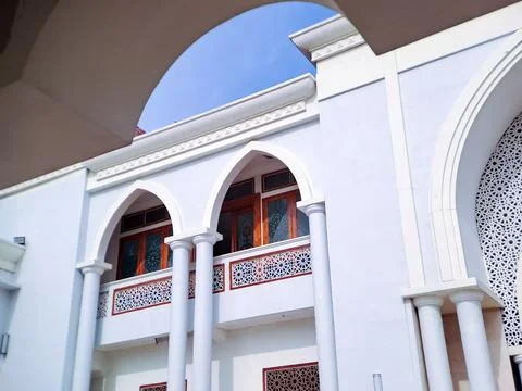 Framed view of a white mosque facade with arched windows and balconies, set.. Stock Photos