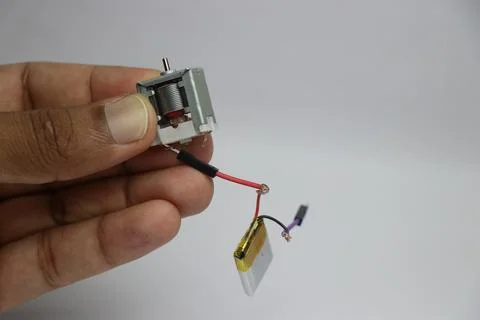 Frameless dc motor connected to a small lithium polymer battery Stock Photos