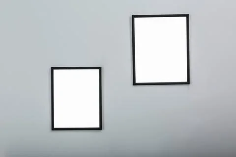 Frames with empty canvases on wall in modern art gallery. Mockup for design Stock Photos