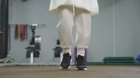 Frames without a face, Muslim woman jumping rope in the gym. Close-up of the Stock Footage 149749615