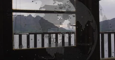 Framing centered mountain range through glass with dotted globe, faint text, 写真素材