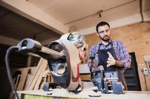 Framing contractor using a circular cut off saw to trim wood studs length Stock Photos