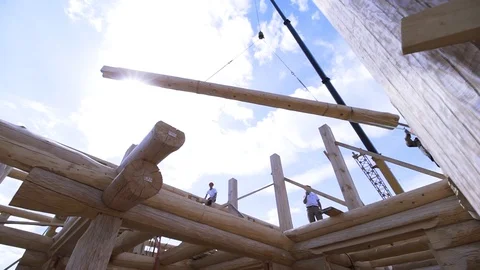 Framing of house under construction, installing of the roof elements on blue Stock Footage 122200549