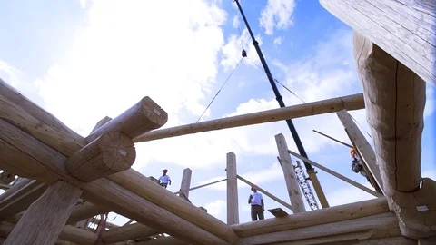 Framing of house under construction, installing of the roof elements on blue Stock Footage 122200627