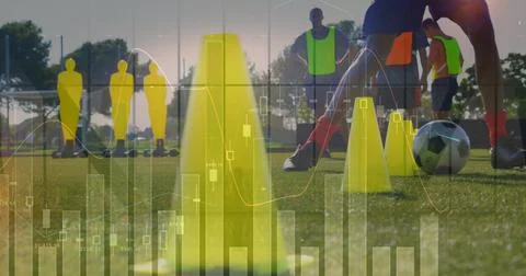 Framing large yellow cone on grass pitch, showing neon bibs, soccer ball, Stock Photos
