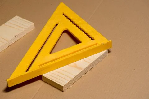 Framing square prepared to used to mark a diagonal line on a pine wood board Stock Photos
