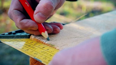 A framing square is used to mark a wooden beam Stock Footage 74804341