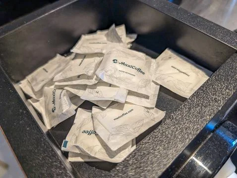France, 10 August 2024 : Maxicoffee sugar packets arranged in a black compart Stock Photos