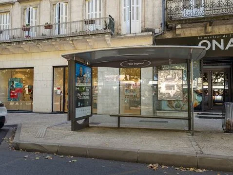 France, 16 August 2024: Empty bus stop shelter on urban street with buildin.. Stock Photos
