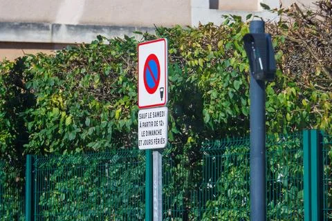 France, 16 August 2024: No parking sign in front of green bushes and fence. Stock Photos