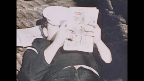FRANCE - 1944: a sailor reads a comic book on deck Stock Footage 340399719