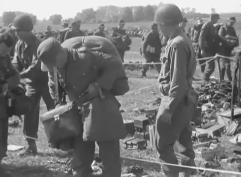 FRANCE - 1944: Surrender processing - Prisoners deposit kit inside a roped area Stock Footage 344488981