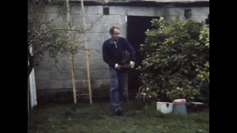 France 1974: a bricklayer comes down the ladder with bricks in his arms Stock Footage 304663973