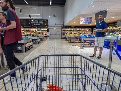 France, 27 August 2024: Interior of supermarket with shopping cart and peop.. Stock Photos