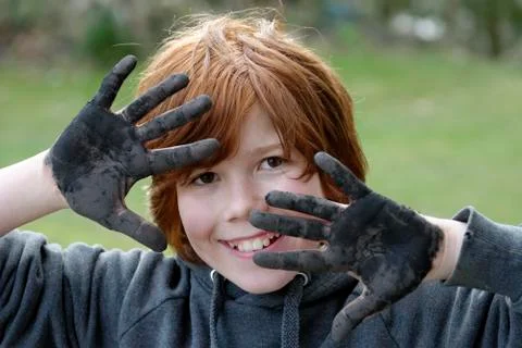 France, boy showing dirty black hands, smiling, close up Stock Photos