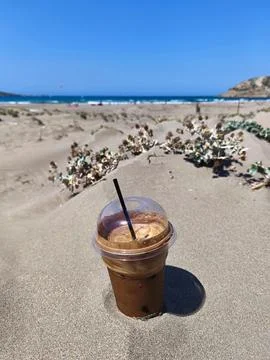Frappe Cold refreshment iced coffee on a sandy beach. Freddo espresso refre.. Stock Photos