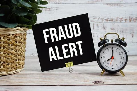 Fraud Alert text with alarm clock on wooden background Stock Photos
