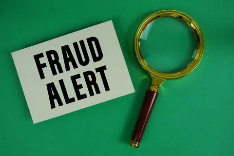 Fraud Alert text written on paper with magnifying glass Stock Photos