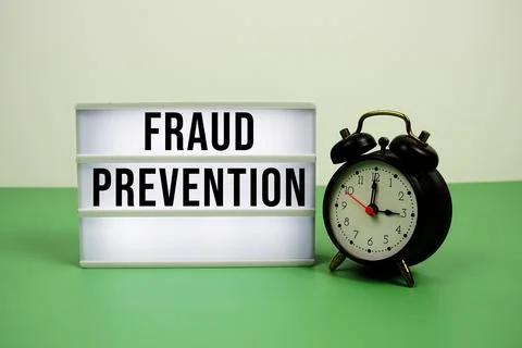 Fraud Prevention text on LED lightbox with alarm clock on green background Stock Photos