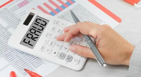 Fraud text on a calculator with financial data paperwork Stock Photos