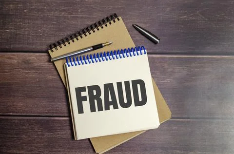 FRAUD text written on notepad on the wooden background Stock Photos