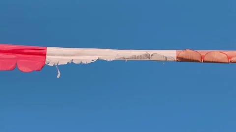 Frayed Red and White Banner Hanging Against Clear Blue Sky Stock Footage 346017291
