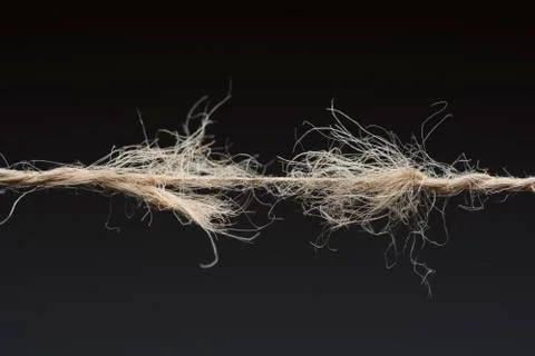 Frayed rope ready to break on dark background Stock Photos