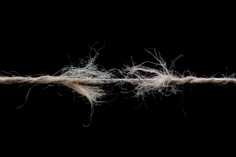 Frayed rope ready to break isolated on black background Stock Photos