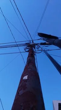 Frayed wires over rusty electricity poles Stock Photos