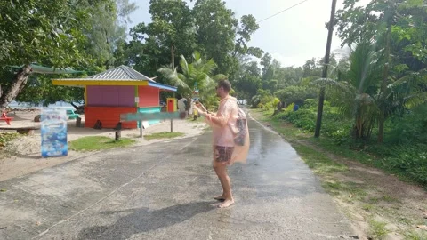 Freak guy dancing in the rain on La Digue island, Seychelles. Stock Footage 155797468