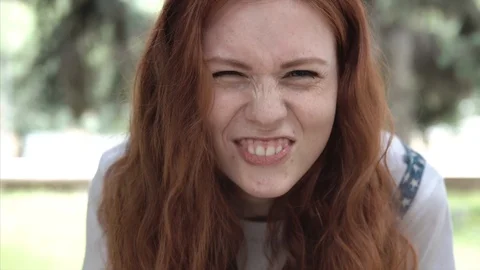 Freckled ginger girl making faces in park. Stock Footage 112580977