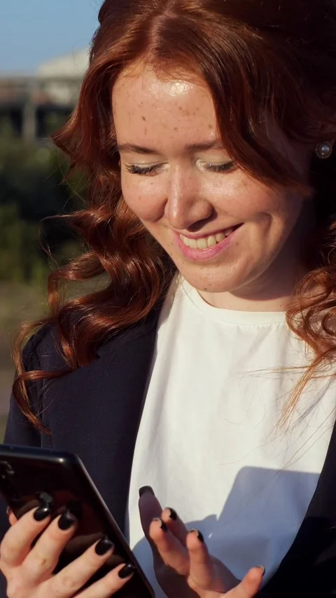 Freckled red haired woman using smartphone outdoors Stock Footage 341186217