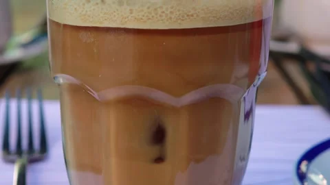 Freddo espresso preparation, milk foam gently poured into coffee glass Vidéo 310408747