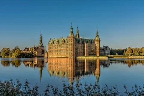 Frederiksborg Castle in a mirror-gloss reflection at surise Stock Photos
