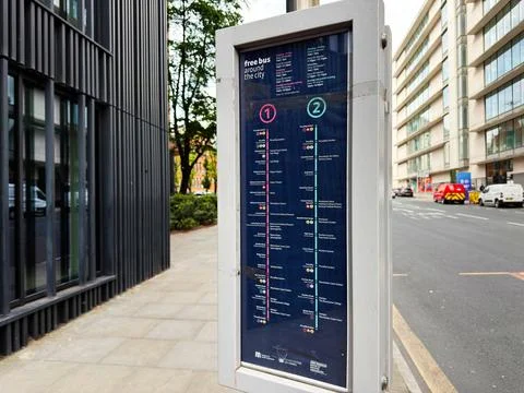 Free bus route map display on a street kiosk in Manchester UK showing timet.. Stock Photos