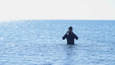 Free diver in wetsuit preparing to dive underwater in sea Stock Footage 133260002
