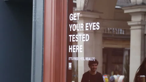 Free eye test service at a store in London with a sign offering free testing Stock Footage 306581665