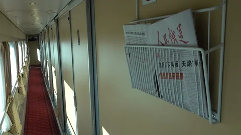 Free newspaper in first class carriage on Qinghai - Tibet train in China Stock Footage 112998466