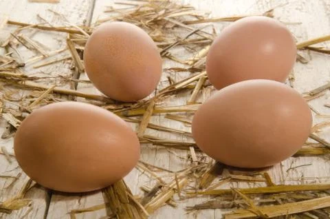 Free range eggs with straw on an old wooden table Stock Photos