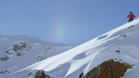 Free style skier making turns while skiing down the snowy mountain slope Stock Footage 116741632